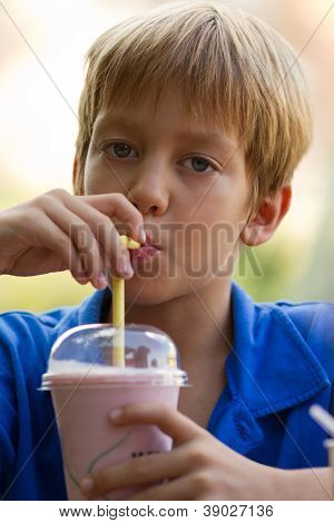 Rolig liten pojke drycker Milkshake