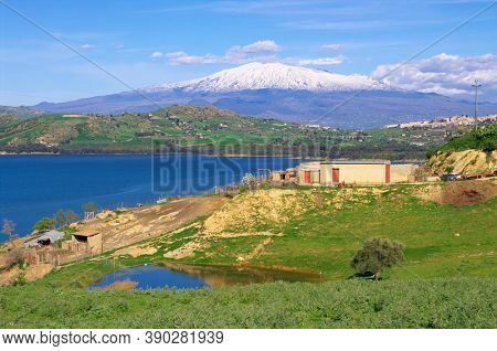 farm landscape of Sicily countryside around Etna Volcano snow covered with lake and pond