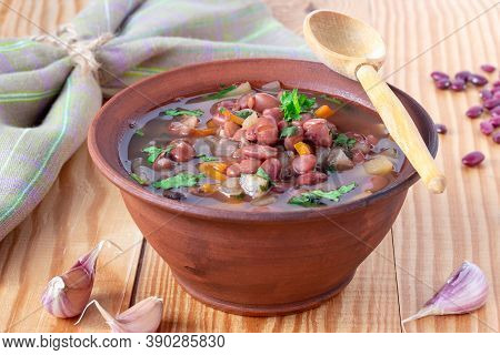 Bean Soup With Cilantro In Clay Plate On Wooden Background. Rustic Style