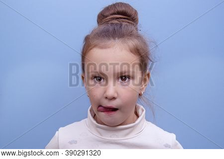 A Girl With A Beam On Her Head Pulls Her Tongue Aside For For The Development Of Speach. Speech Ther