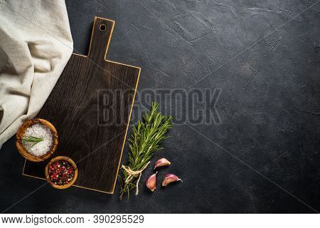 Food Cooking Background On Black. Black Wooden Cutting Board, Herbs And On Black Stone Table. Top Vi