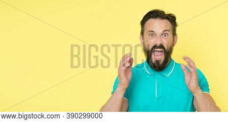 Overwhelmed With Emotions. Handsome Shouting Mature Man Screaming Standing Against Yellow Background