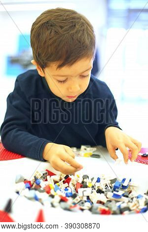 Little Dark-haired Boy Plays With Multicolored Block Details
