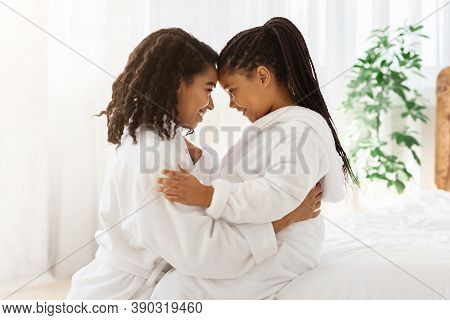 Portrait Of Happy Embracing Black Mom And Daughter In Bathrobes At Home, Bonding With Each Other, To