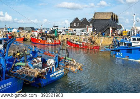 Whitstable Harbour, Kent, England - Oct 14 2020: Colourful Fishing Boats And Trawlers On A Bright, S