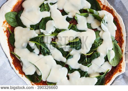 Plant-based Food, Vegan Pizza With Cashew Cheese  And Spinach About To Go In The Oven