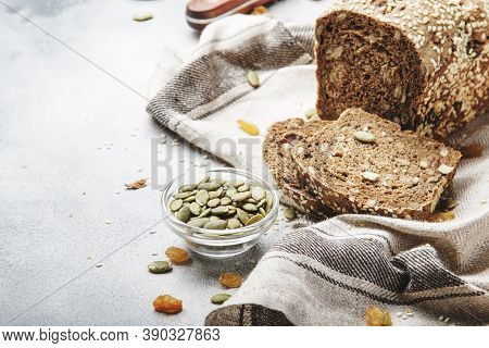 Whole Wheat Organic Rye Dark Bread With Pumpkin Seeds, Dried Fruit, Raisins And Sesame Seeds On Gray