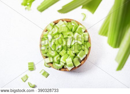 Fresh Green Celery Chopped Pieces In Bowl, White Background, Top View, Copy Space