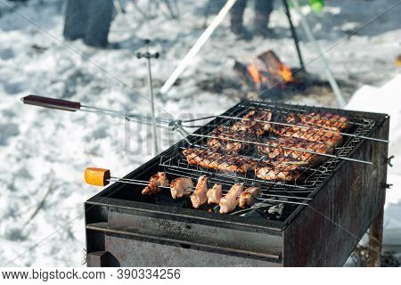 Winter Barbecue Outdoors, Grill Steak And Fork With Meat Over Hot Coals In A Bbq At Campside Cookout