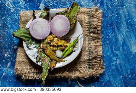 Cooked Indian Carplet Fish Or Mourala Fish With Spices And Onion Slices In A Plate Isolated On Bluis