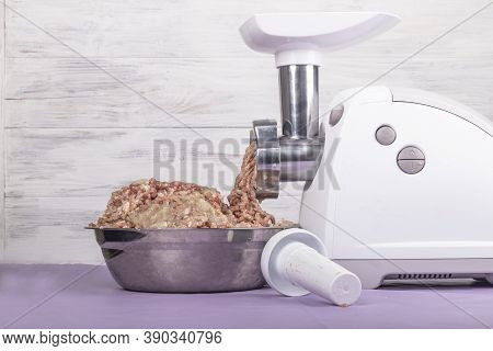 Electric White Meat Grinder. Minced Meat Is Wound And Lies In A Metal Bowl. Copy Space. Text.