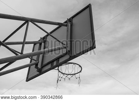 The Back Image Of The Basketball Board Hoop With The Loop On The Sky Background. Black And White Sty