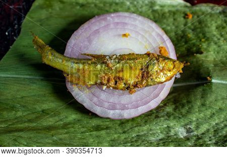 Closeup Of Cooked Indian Carplet Fish Or Mourala Fish On Onion Slice Isolated On Turmeric Leaf