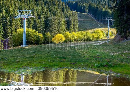 Bansko, Bulgaria Shiligarnika Autumn Ski Resort View With Mountains And Ski Lift Reflection In Puddl