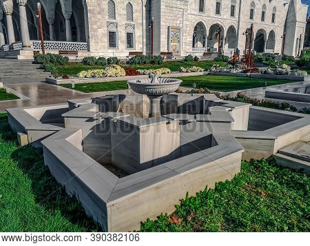 Turkey, Ankara - October 23, 2019: Garden with white marble fountains near Melike Hatun Mosque in Ankara. Amazing landscaping in the courtyard of the mosque with flower beds and green grass on the lawn