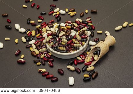 Mix Of Various Dry Legumes In Ceramic Bowl, Scattered On Black Stone Background
