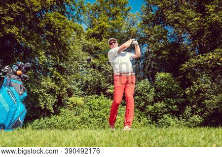 Golf player at the tee hitting ball far, tele shot