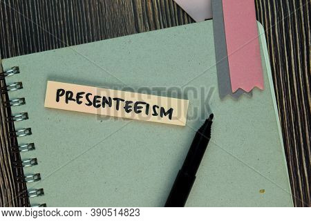 Presenteeism Write On Sticky Notes Isolated On Wooden Table.