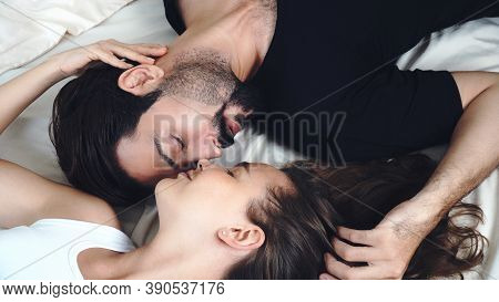 Romantic Young Couple Resting And Lying Down Face To Face Together On The Bed At Home. Husband And W