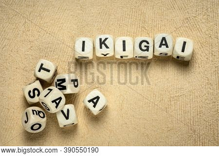 ikigai word abstract in wooden letter cubes against handmade bark paper, Japanese lifestyle concept  - a reason for being as a balance between love, skills, needs and money