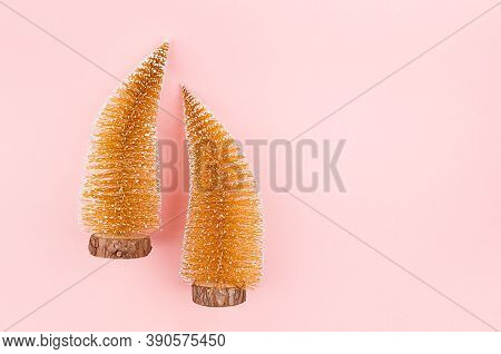 Festive Gentle New Year Background With Glitter Gold Christmas Trees On Pink Backdrop, Top View.