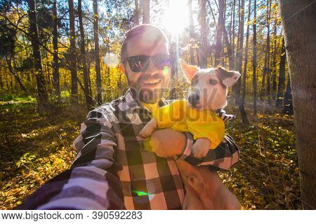 Man Taking Selfie With His Dog At Autumn Park. Guy Posing With Jack Russell Terrier For A Picture On