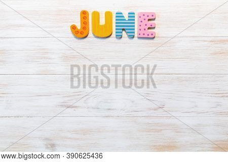 Wooden Letters Written June Month On Vintage Background. Inscription June With Copy Space. Top View.