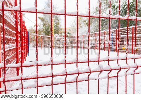 The Basketball Court, Closed By A Red Fence, Is Covered With Snow.