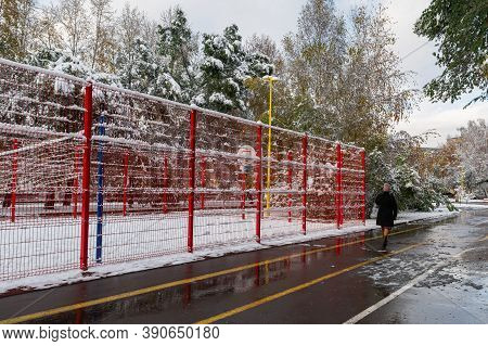 In The Winter Park, There Is A Snow-covered Basketball Court Surrounded By A Red Fence.