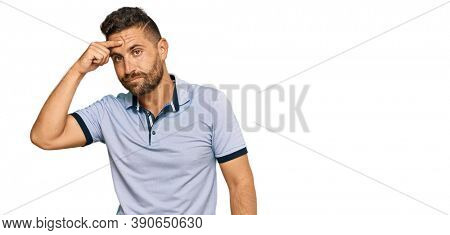 Handsome man with beard wearing casual clothes pointing unhappy to pimple on forehead, ugly infection of blackhead. acne and skin problem 