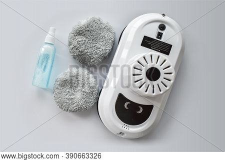 Robot For Washing Windows, Cleaning Agent Andcleaning Pads On A White Background. A Device For Clean
