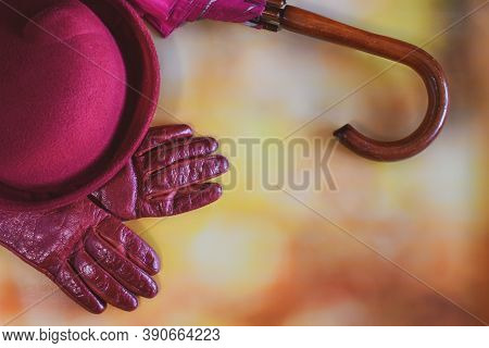 Hat, Leather Gloves And Umbrella On A Blurred Autumn Background. Seasonal Accessories For Autumn Wal
