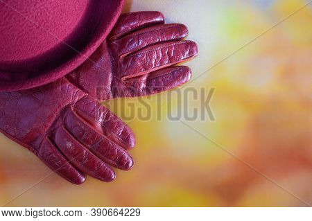 Hat, Leather Gloves On A Blurred Autumn Background. Seasonal Accessories For Autumn Walks. Autumn Fl