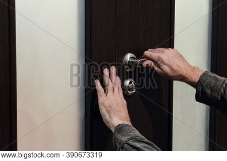 Hands Closing The Double Door. A Man Carpenter Checks The Door Sheet Closing And A Handle With A Loc