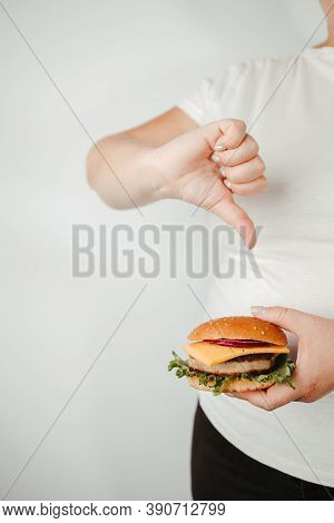 Fast Food, Weight Loss, Diet, Unhealthy Eating. Overweight Woman With Fresh Hamburger And Thumb Down