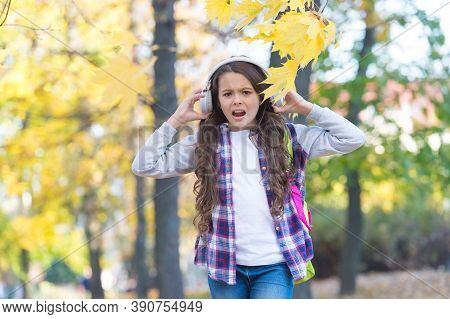 Irritated Little Girl Suffer From Loud Unpleasant Music Sound Cacophony In Autumn Park Outdoors, Hea