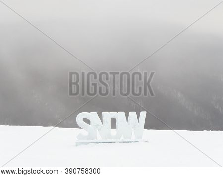 The Inscription Snow Cut From Ice Stands On The Street On A Gray Foggy Day