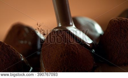 Detail of pralines with pouring melted chcocolate on top. Studio macro shot.