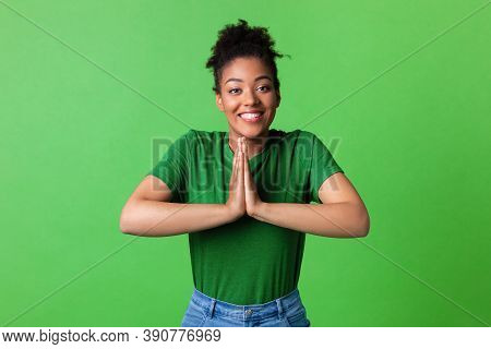 Pleading Concept. Portrait Of Funny Black Lady Keeping Palms Together, Asking For Mercy Or To Buy He