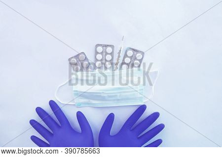 Flat Composition With Medical Gloves, Masks, Thermometer And Pills On A White Background.