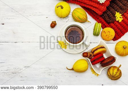 French Macarons In Autumn Colors With Cup Of Hot Tea