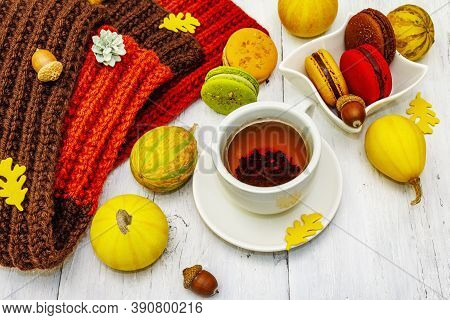 French Macarons In Autumn Colors With Cup Of Hot Tea