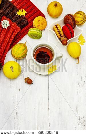 French Macarons In Autumn Colors With Cup Of Hot Tea