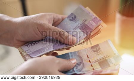 Close Up Of A Person Counting Money, Uang Indonesian Rupiah, Cash In Hand Concept