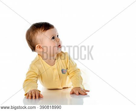 Sad Frustrated Disgruntled Baby Girl Child Creeping On White Floor Background. Unhappy Toddler Kid W