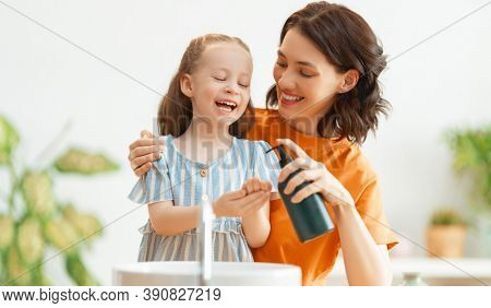 A cute little girl and her mother are washing their hands. Protection against infections and viruses.     