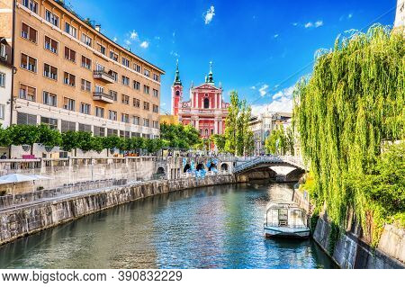 Ljubljana City Center During A Sunny Day Overlooking Lublanka River And Beautiful Franciscan Church,