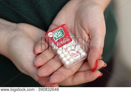 Young Girl Holds Tic-tac Hard Mints Pack With Coca-cola Taste. Tic Tac Is A Brand Of Small Hard Mint
