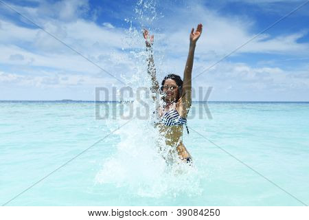 Vrolijke vrij jonge vrouw splashin in zee