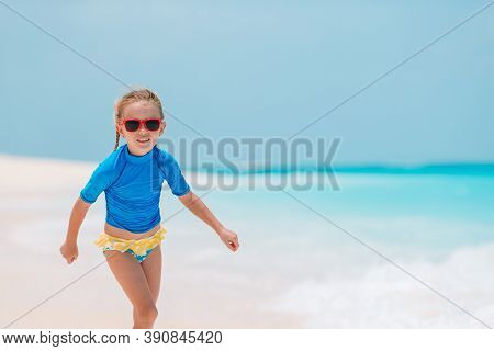 Adorable Active Little Girl At Beach During Summer Vacation